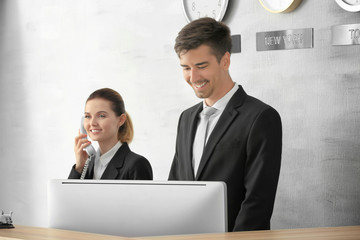 Female and male receptionists working in hotel