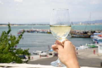 Woman holding glass with white wine outdoors
