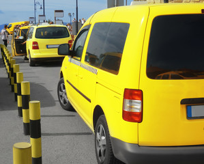 Bright yellow taxi cabs in parking zone