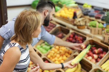 Young couple choosing products at market