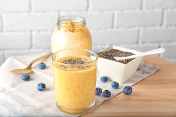 Glass of delicious smoothie with chia seeds on table
