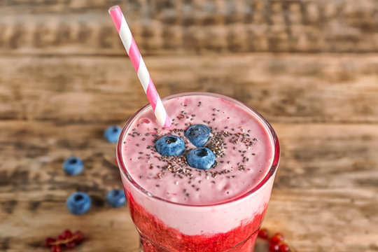 Glass of colorful smoothie with chia seeds on wooden table