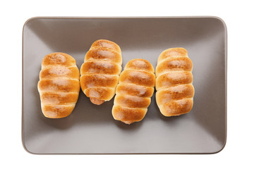 Plate with baked sausage rolls on white background