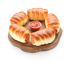 Wooden board with baked sausage rolls on white background