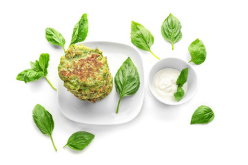 Composition with delicious broccoli pancakes and sauce on white background
