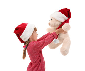 Cute little girl in Santa hat with toy on white background
