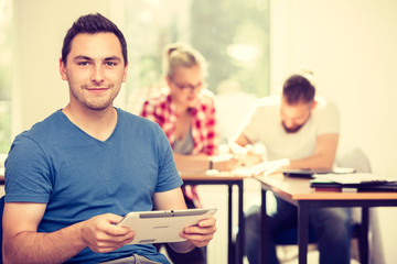Male student with tablet in front of her classmates