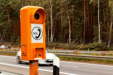 SOS phone. Emergency telephone at the roadside. Morning on the German highway.
