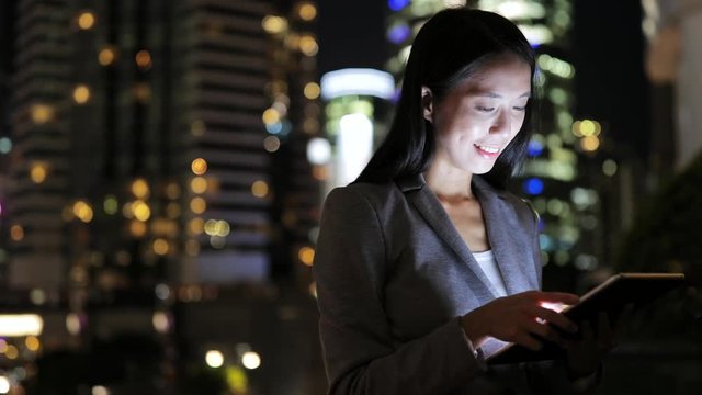 Business woman looking at digital tablet at night