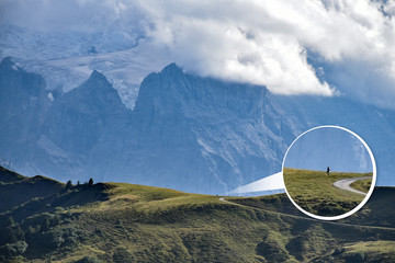 A zoomed-in balloon of a tiny hiker as opposed to the huge mountain range in the background,...
