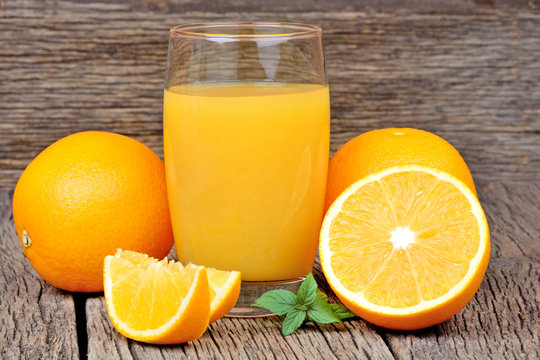 Glass with orange juice on table