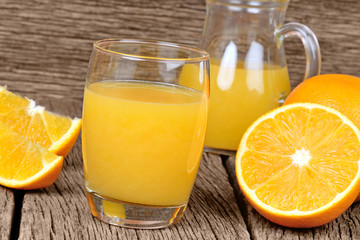 Fototapeta na wymiar Orange juice in a glass and pitcher on table