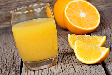 Glass with orange juice on wooden table