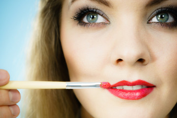 Applying lipstick on fashion model lips