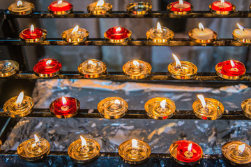 Red and Gold Prayer Candles in Church