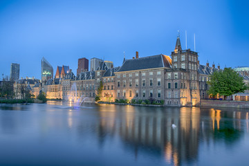 Fototapeta na wymiar Binnenhof Palace of Parliament inThe Hague in The Netherlands Shot During Blue Hour Time. Against Modern Skyscrapers on Background.
