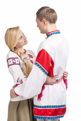 Fototapeta na wymiar Fashion Ideas. Portrait of Loving Embraced Caucasian Couple in National Belarussian and Russian Decorated Costumes. Against White Background.