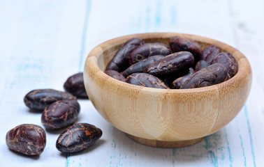 Cacao beans in a bamboo bowl on table