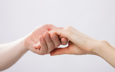 Man's hand gently holding woman's hand