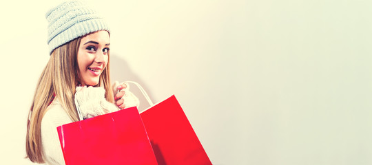 Happy young woman holding shopping bags on a white background