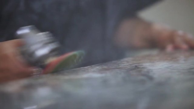 detail footage of worker polishing granite edge