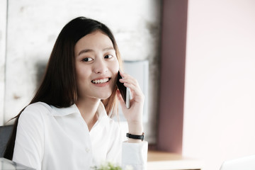 Young businesswoman talking smart phone at office background, business communication concept