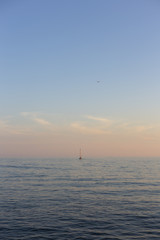 sailboat on lake ontario canada travelling in the distace into the sunset