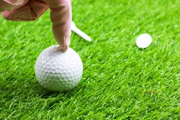 finger is pointing at golf ball