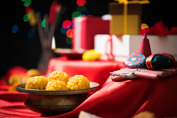 stock photo showing Diwali still life with Diya or oil Lamp, gift boxes, sweets and fire crackers...