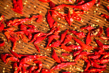Red pepper being dried in the sunlight on a bamboo basket