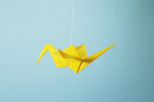 yellow origami crane flying