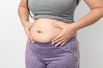 Overweight woman hand pinching excessive belly fat on gray background, Healthy concept