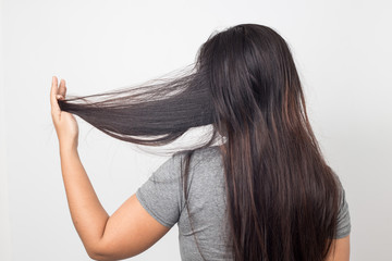 woman holding messy damaged dry hair in hands. back view,Haircare concept