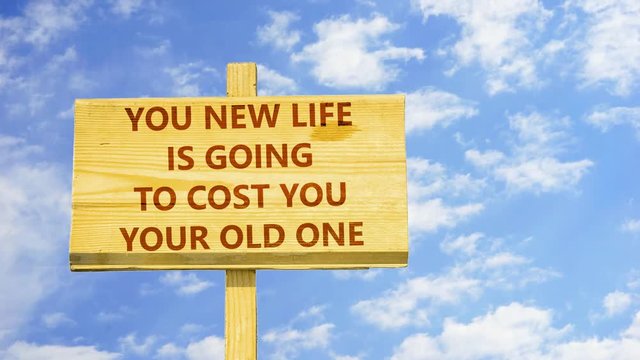 You new life is going to cost you your old one. Words on a wooden sign against time lapse clouds in the blue sky. 