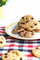 Homemade chocolate chip cookies and nut on a plate with white background