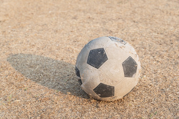 Old football on dried grass