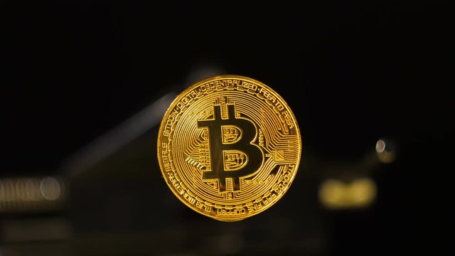 Closeup Golden Shining Bitcoin Model with Dropped Water