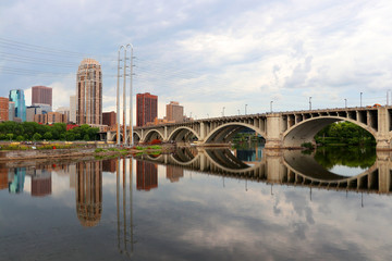 Cloudy morning in Minneapolis. Minneapolis downtown skyline and Third Avenue Bridge above Mississippi river. Midwest USA, Minnesota state.