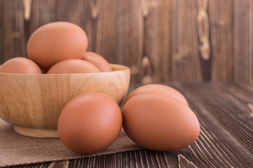 Fresh Eggs in bowl on brown wooden board