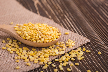 Mung beans in wooden spoon put on wooden plank background