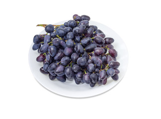 Cluster of the blue grapes on a white dish