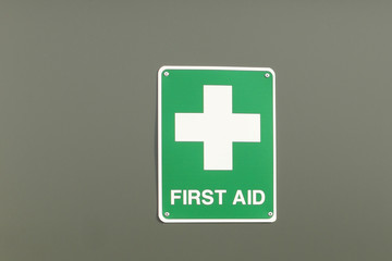green and white First Aid sign and cross
