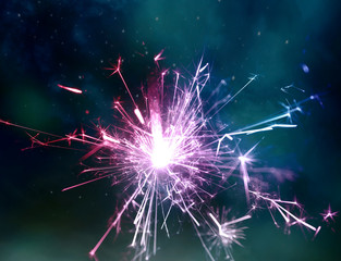Sparkler fire and night sky as background.