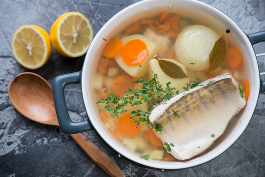 Above view of fresh fish soup or russian ukha with sudak, closeup, studio shot