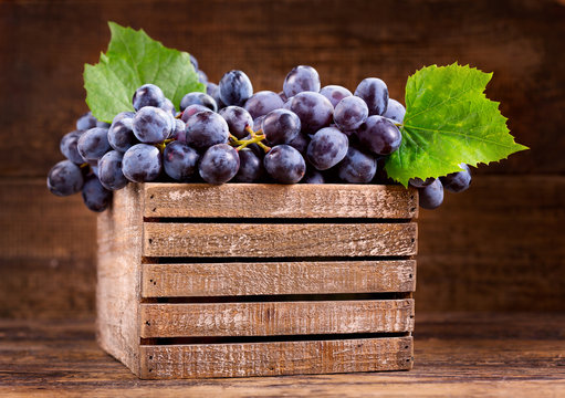 fresh grape with leaves in a wooden box