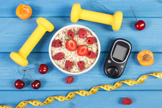 Glucose meter, oat flakes with fruits, dumbbells and centimeter, concept of diabetes, slimming and healthy lifestyle