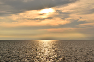 The sunset and the light reflects on the water surface.