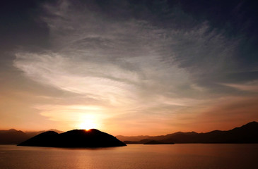 Naklejka na ściany i meble Mountain, ocean and gradient sky at sunset