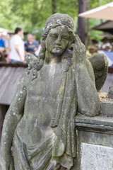 Stone statue of a woman and people in the background.