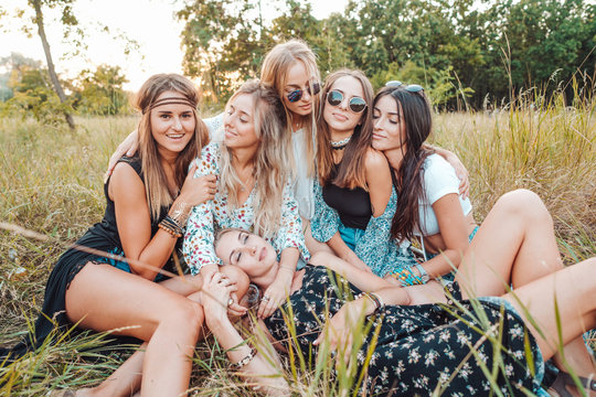 Six girls in nature are sitting on the grass.